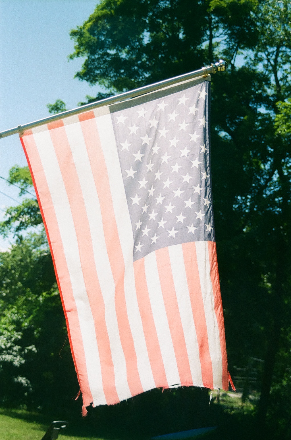 A faded and worn flag, with the sun shining through it.