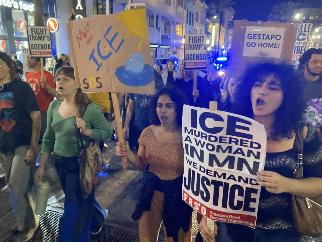 Protesters hold signs demanding ICE get out of New Orleans and justice for Renee Good.