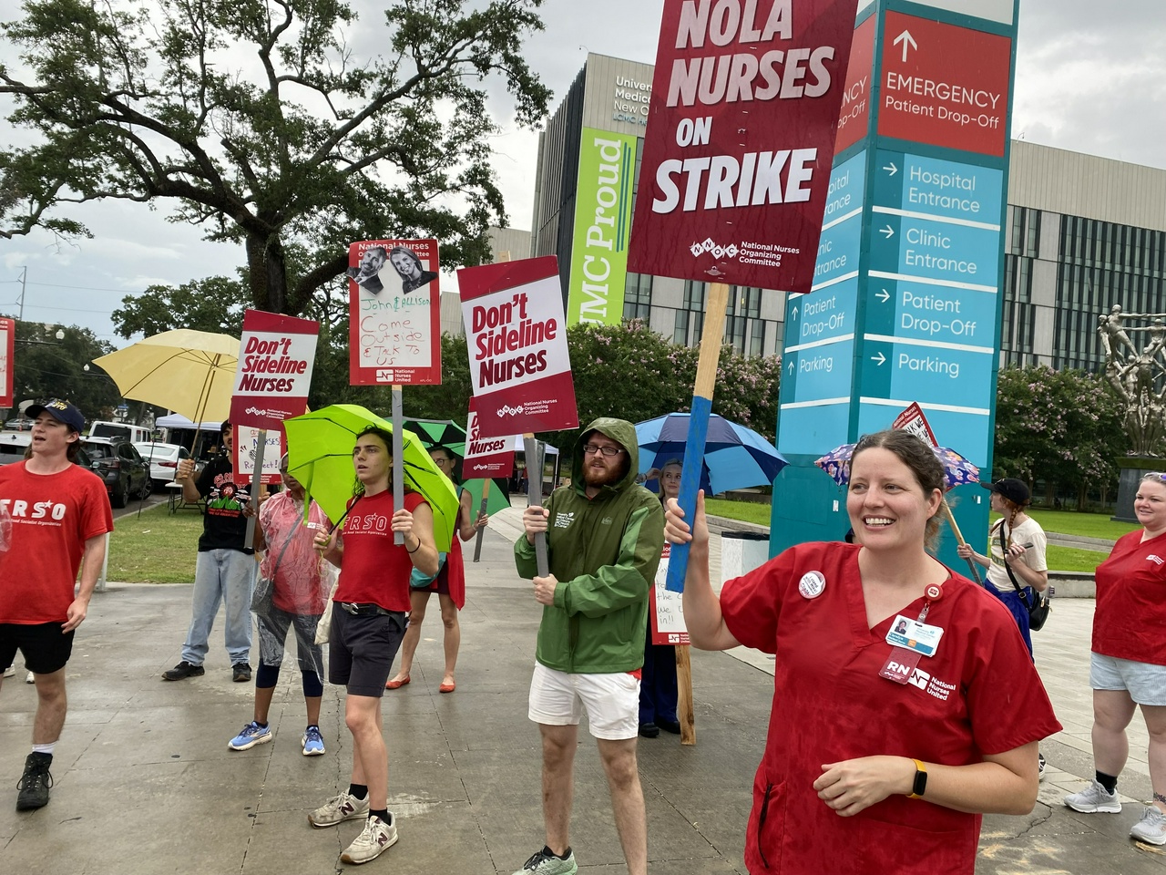 A group of nurses on strike holding picket signs.