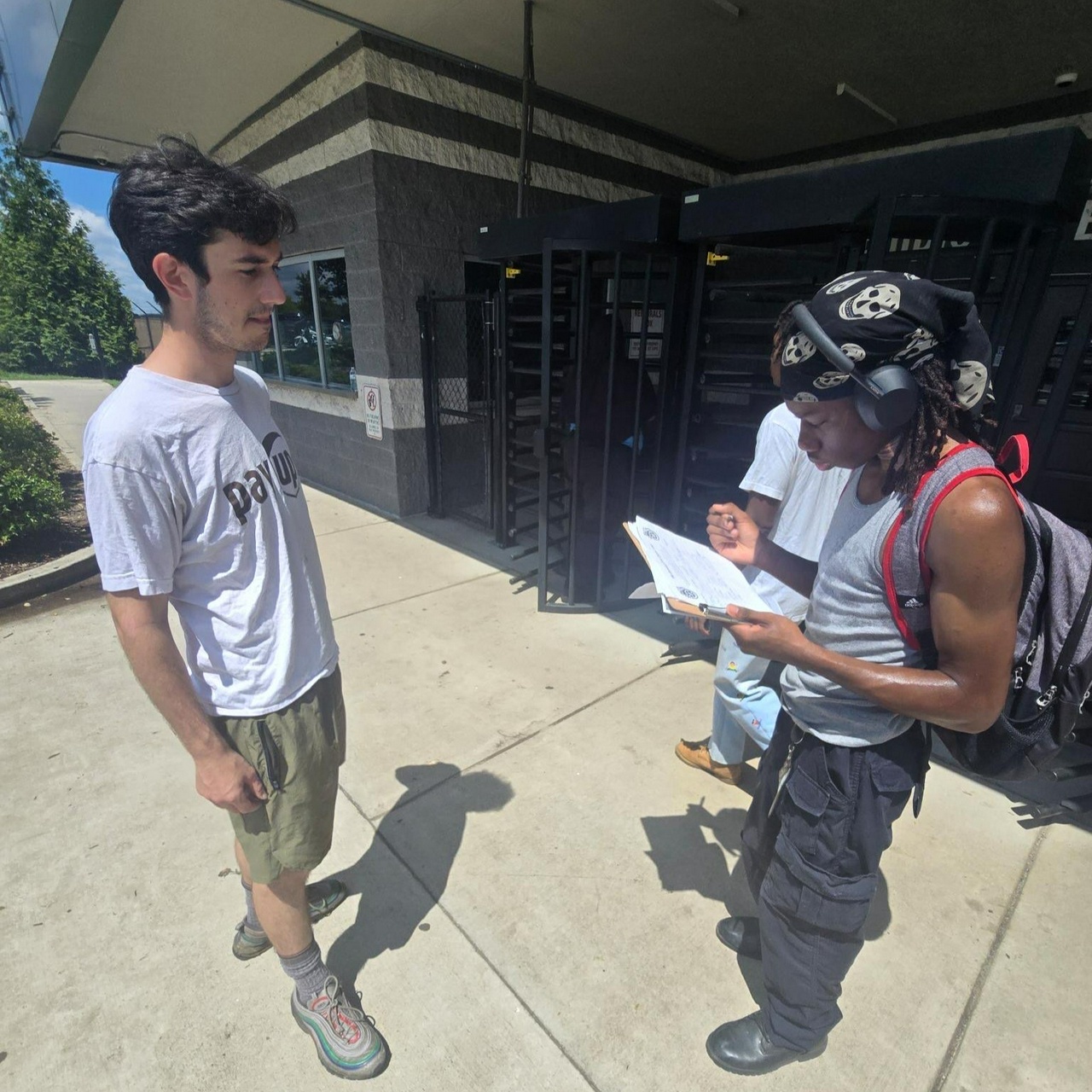 A worker signing a petition on a clipboard.
