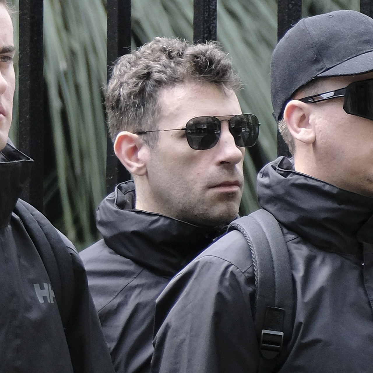 A man in small aviators with short, fluffy, mousy brown curls