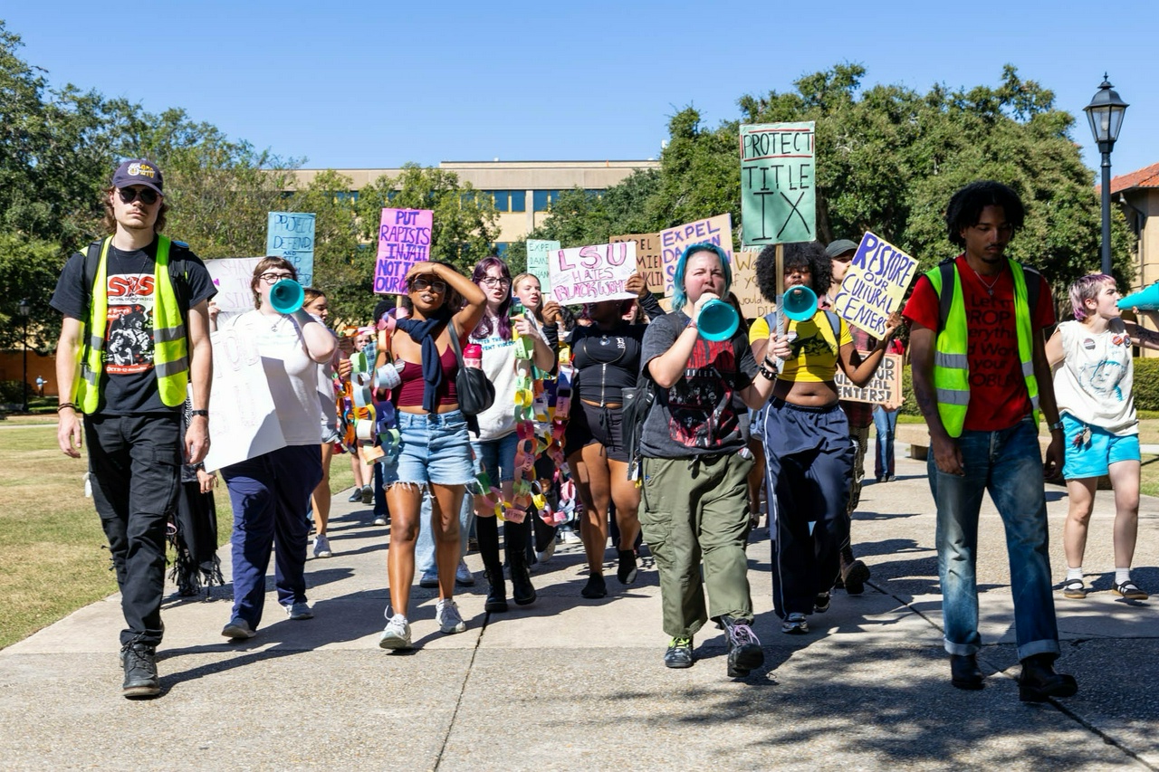 Protesters marching on campus with signs.