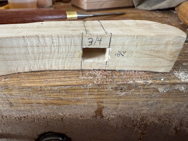 The cane handle rests on my workbench with the mortise squared up