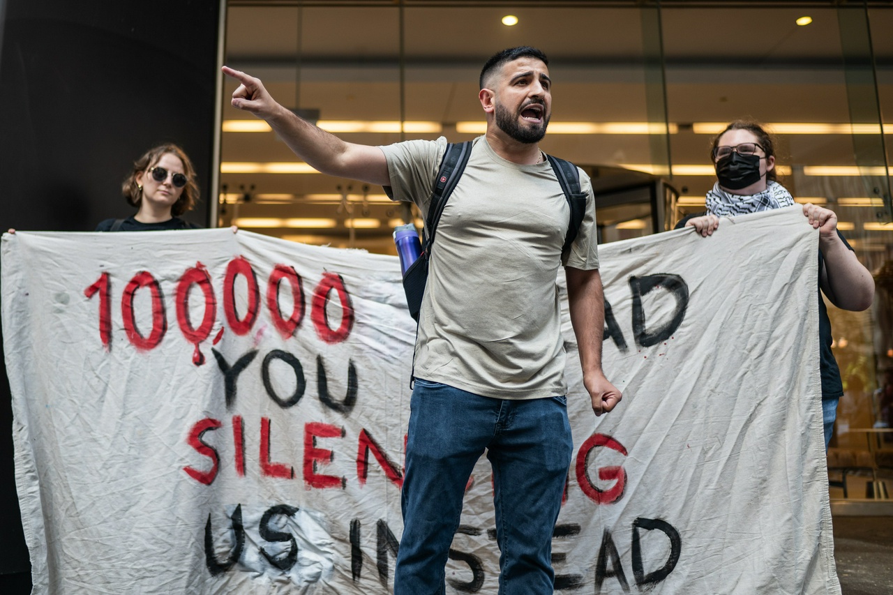 A protester speaking in front of a banner.