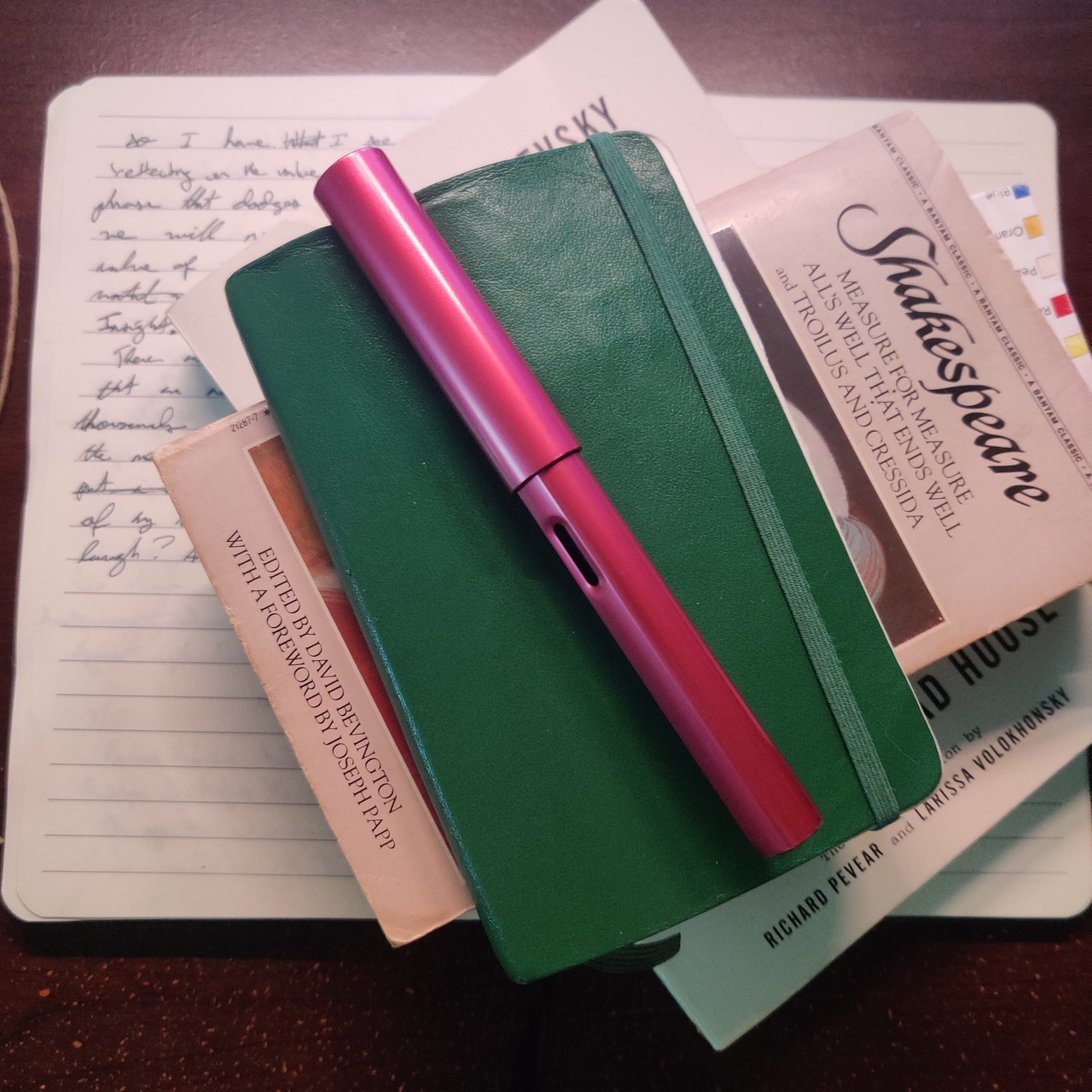 A stack of books mentioned in this post on top of the journal used to draft the first paragraph.