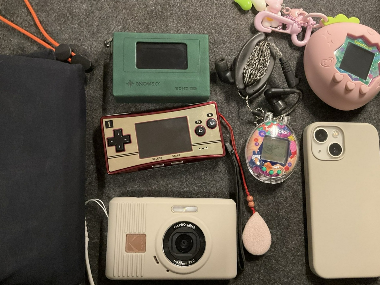 a photo of my Hobonichi, music player, earphones, digital camera, Tamagotchi, and phone