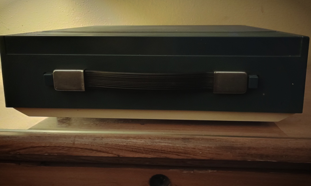 Image of a blue and cream-colored box with a handle and buttons at the side of the handle.