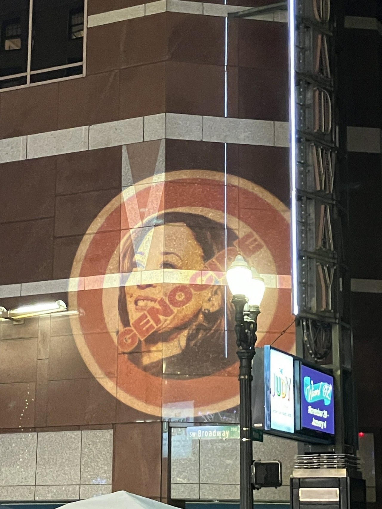 An image of Harris with the text “genocide” written across her face projected on the speaking venue.