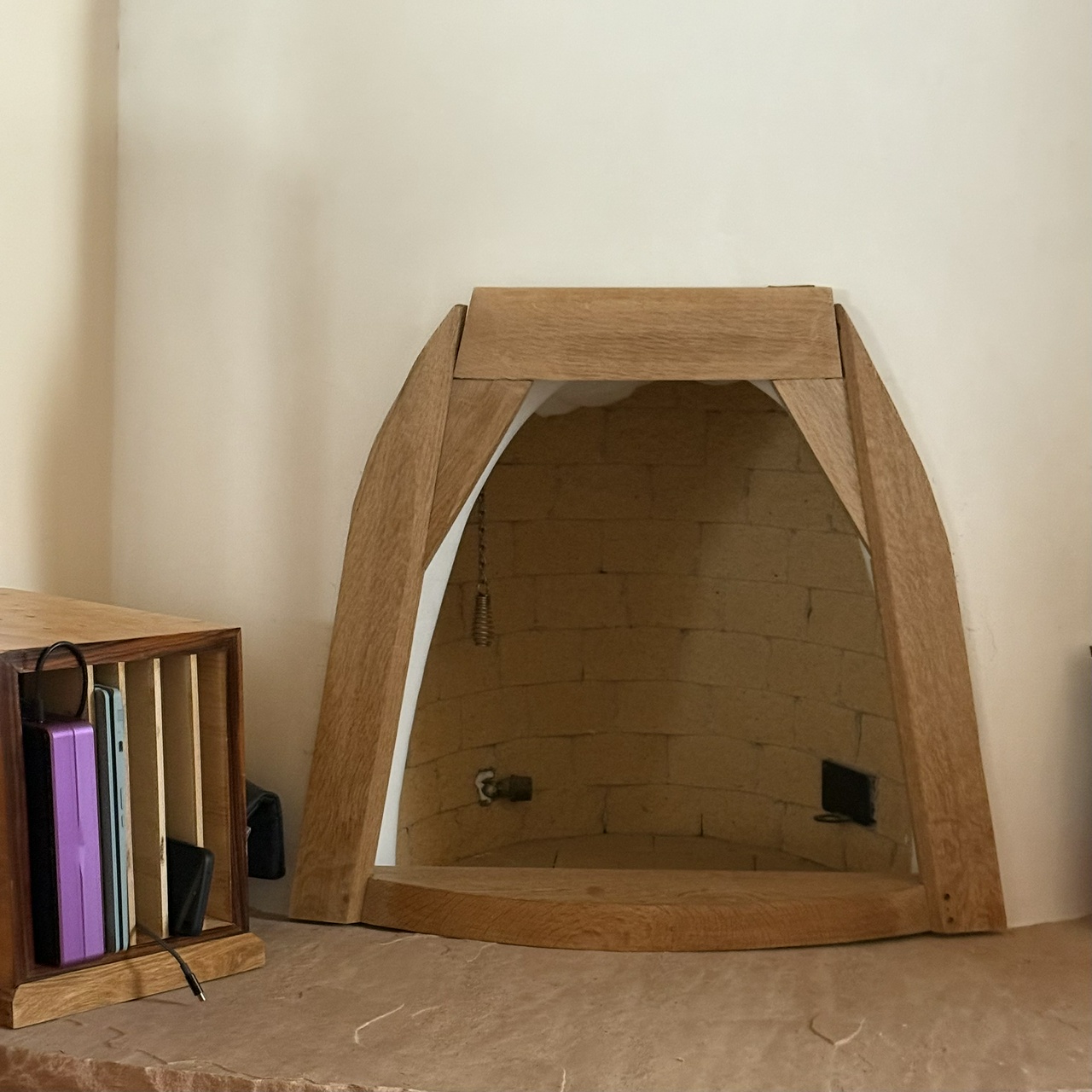 A wooden frame sitting in front of a curved kiva-style fireplace