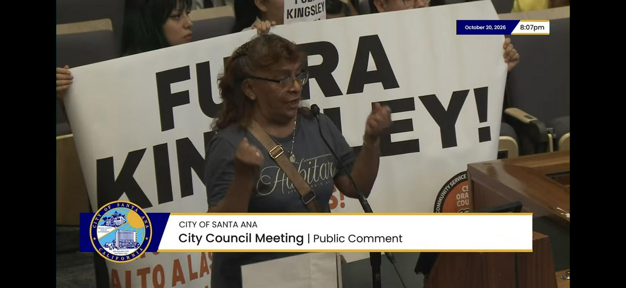 Coach royal resident gives public comment while 2 CSOOC members hold banner behind her
