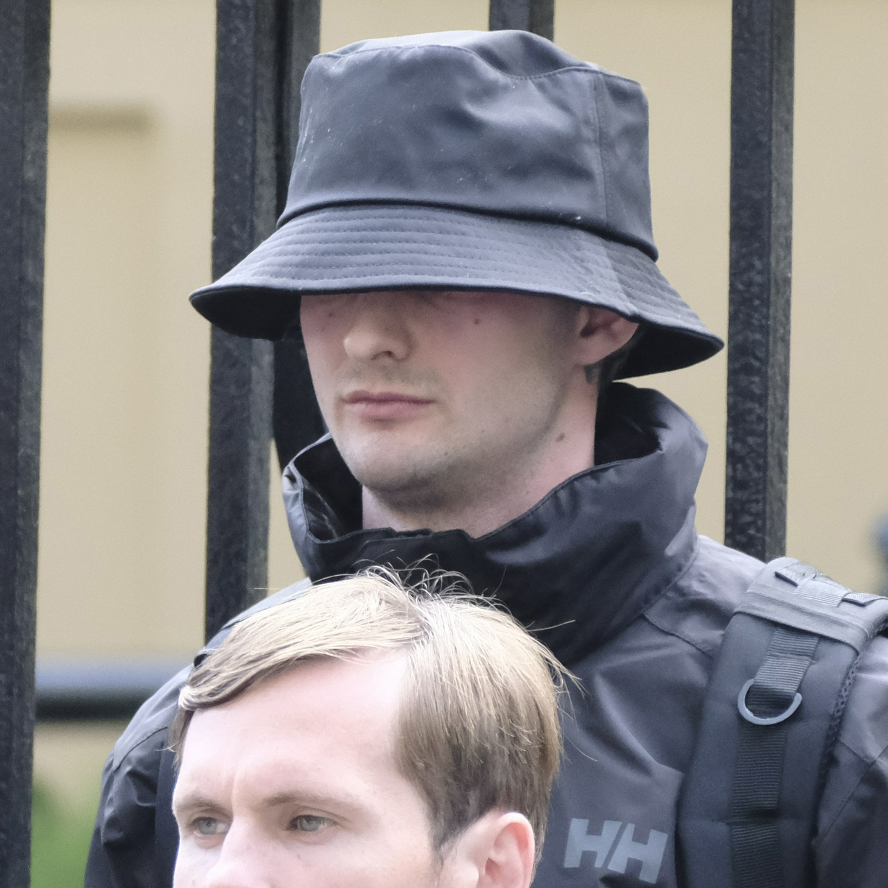 The same man from another side. He has thin lips and deep lines under his eyes