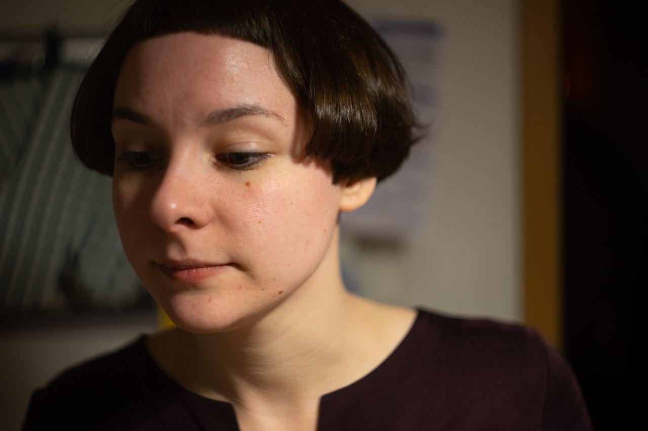 portrait of a woman, with light source right of her head so the left side of her face is less lit than the right.