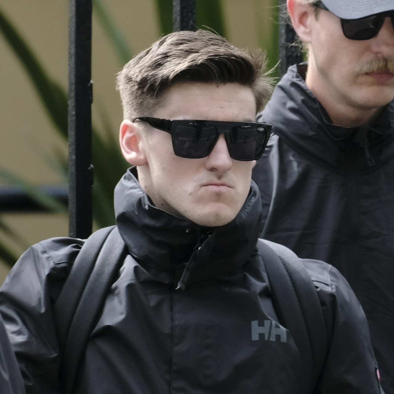 Sean Robert's tiny mouth drawn tight over his massive underbite, with flat-top black sunglasses