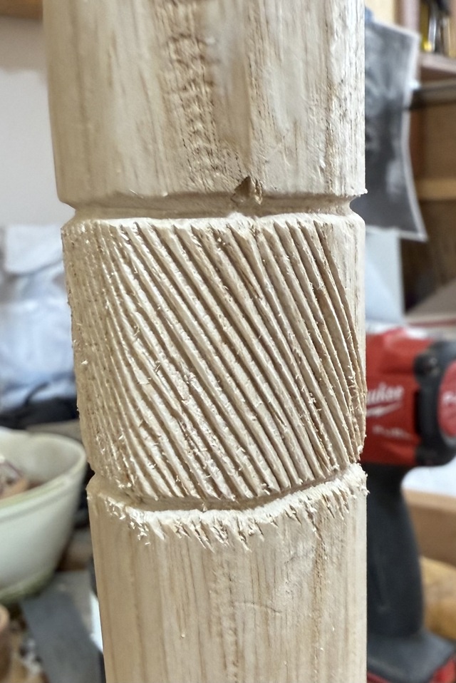 The top of the cane-shaft, with grooves cut into it running top-left to bottom-right - the grooves are fairly close together, and a little over an inch long