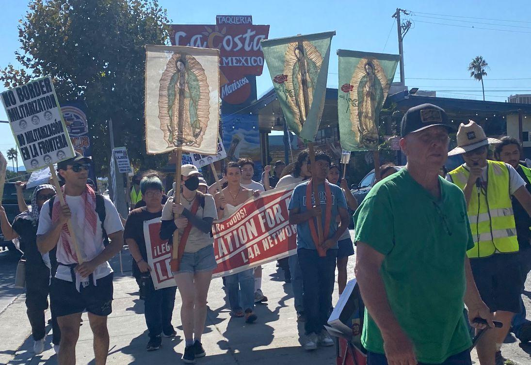Protesters march through San Jose and hold up signs that say 