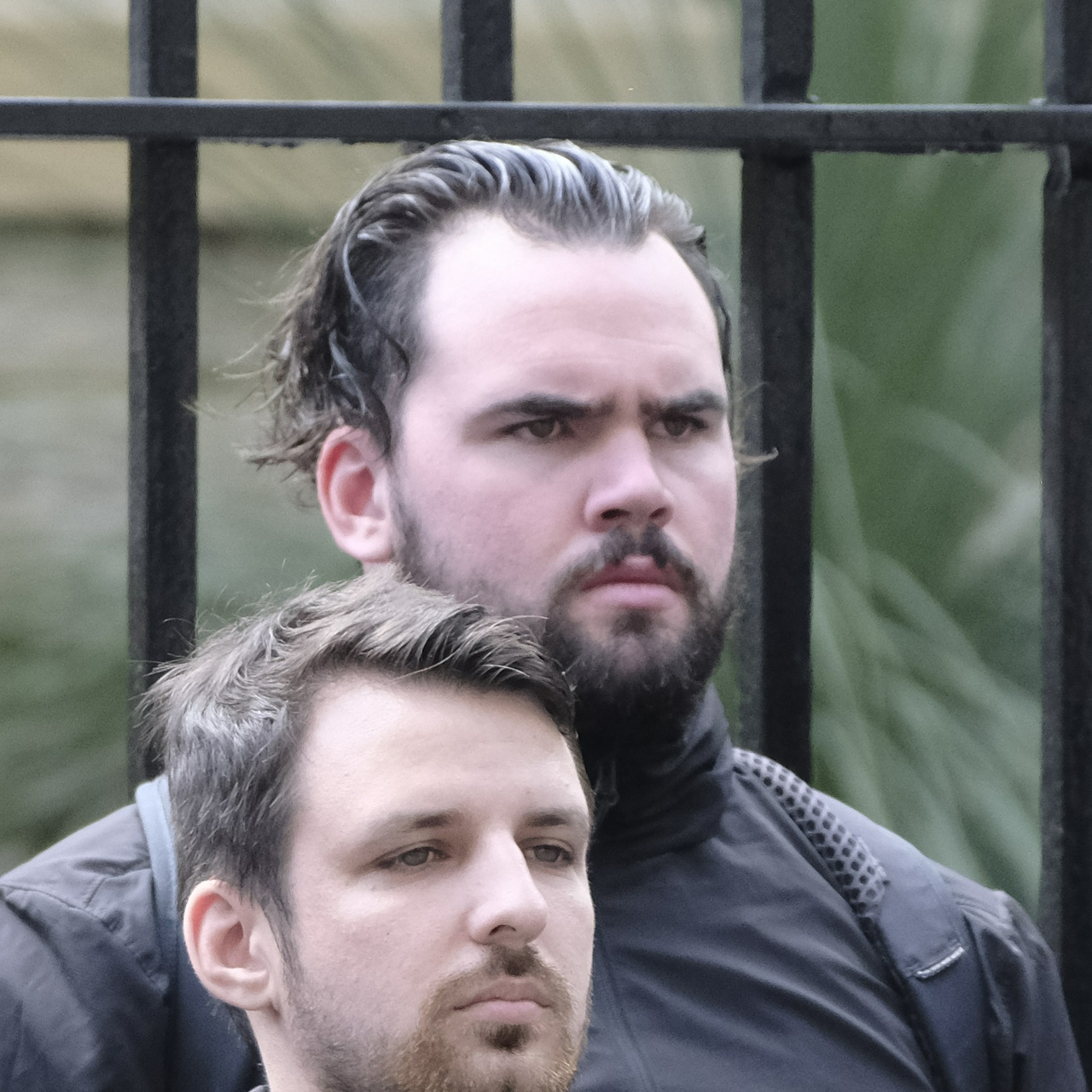 A fat angry looking man with greased black hair and a scruffy beard glares straight ahead