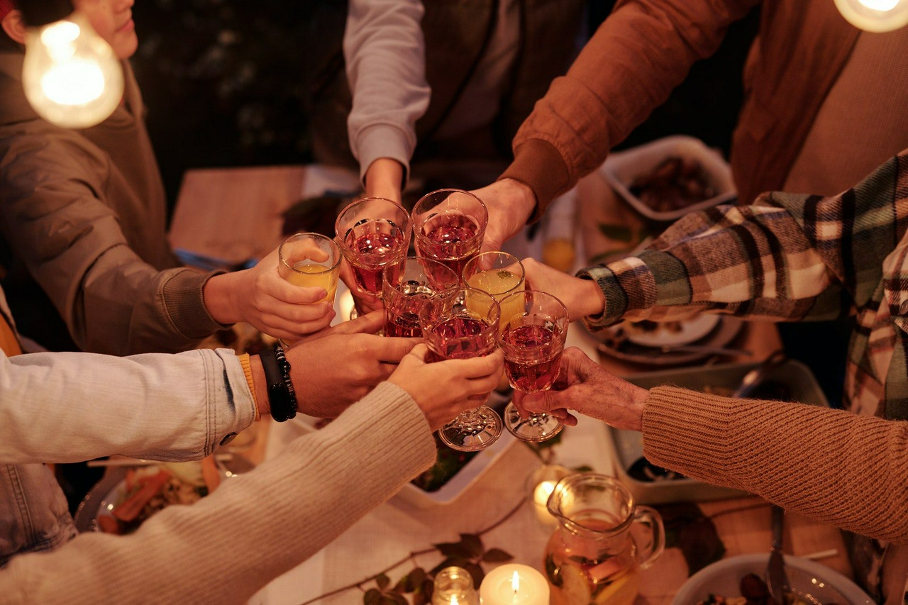 A group of people clinking their glasses together in a celebration toast.