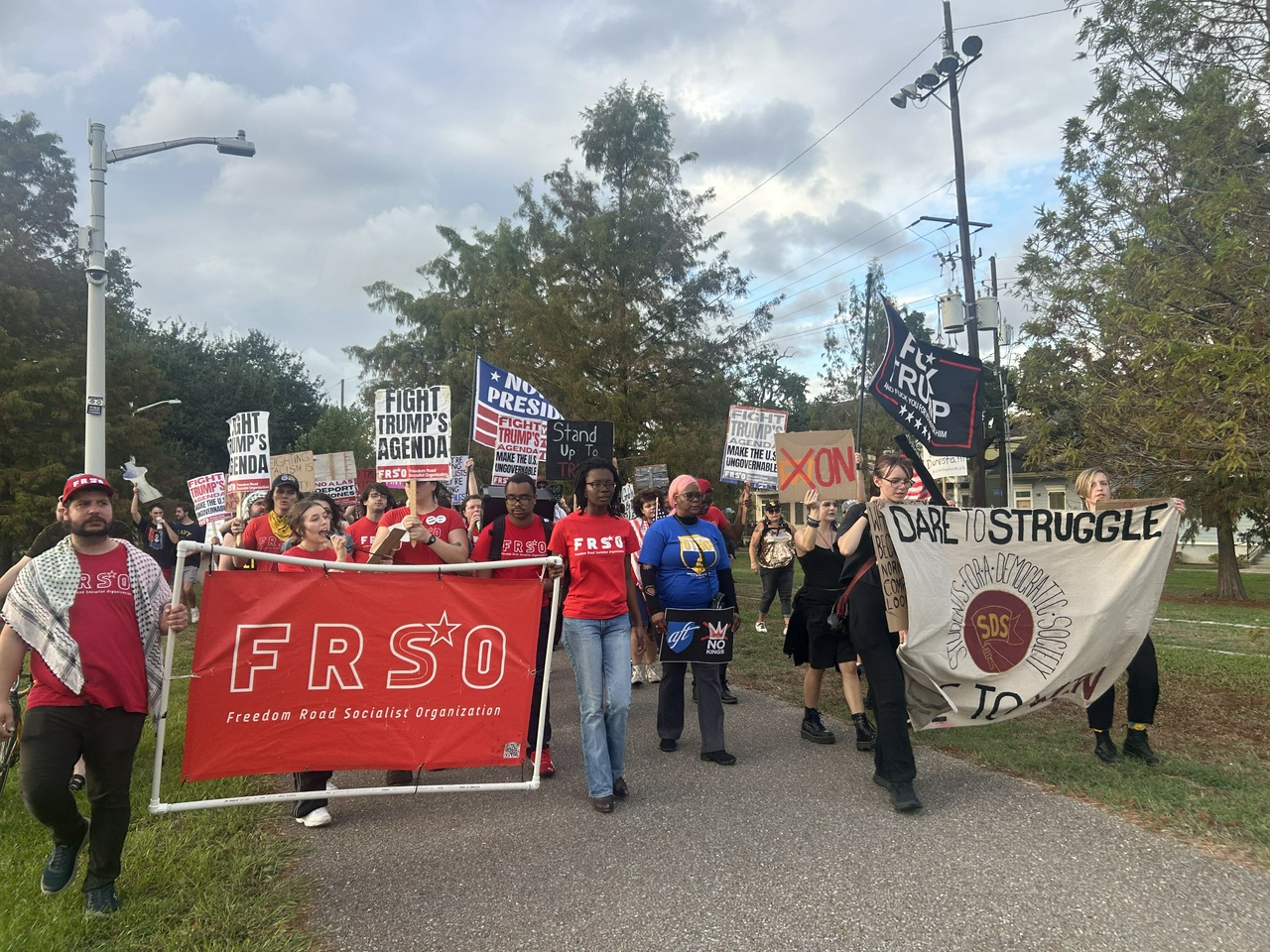 Protestors march back down Lafitte Greenway to close out Saturday's No Kings demonstration.