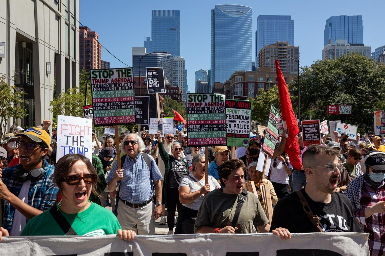 Photo Credit: Fight Back! News | Chicago Labor Day march. Angry protesters march forward with signs that say, "Stop Trump's Agenda! Fight the Trump Agenda!"