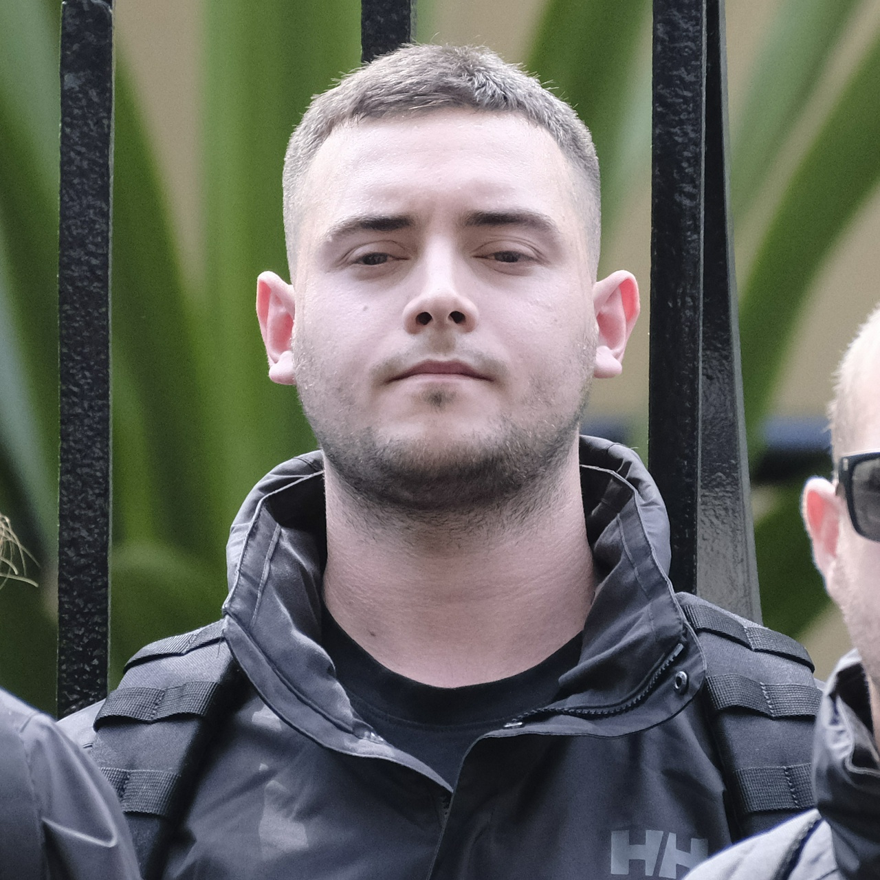 A white man with a wide neck and protruding features stares forlornly down the camera lens