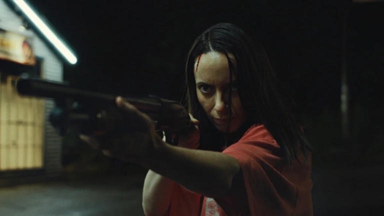 Patricia aims a shotgun