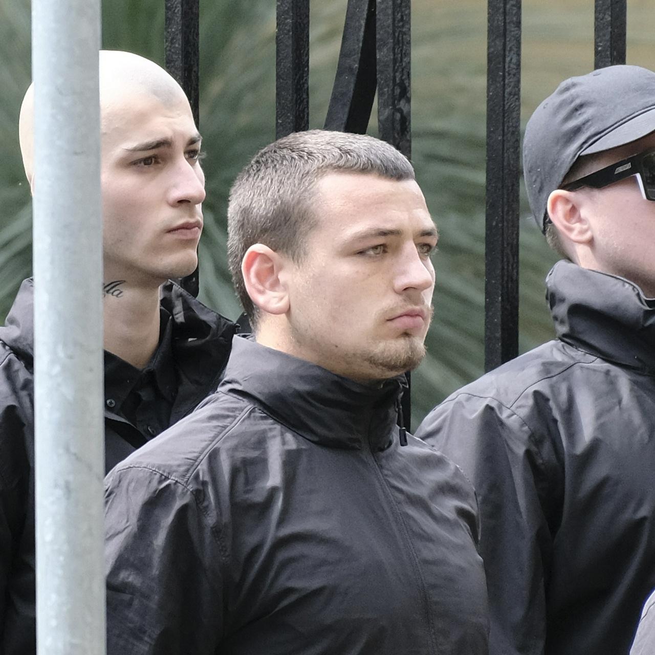 A dusky man with short brown hair, light brown eyes and short fluffy facial hair