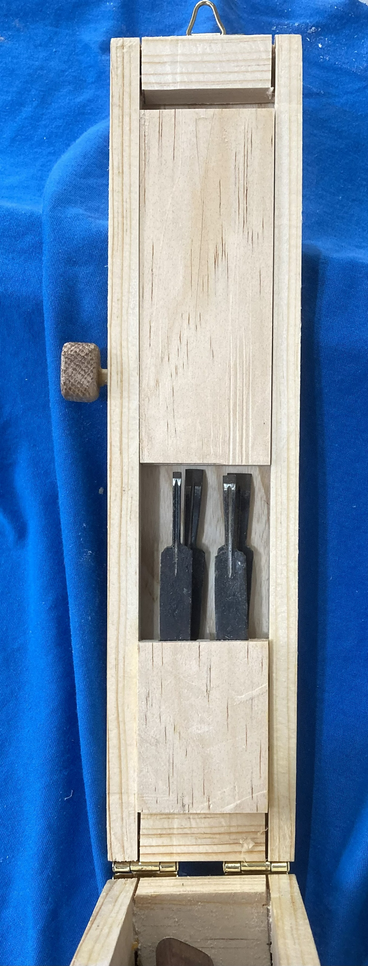 Blades with retaining block and peg holding them in place in the lid of the box