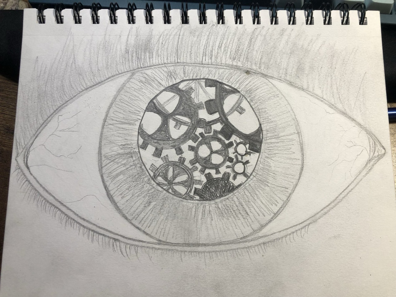 a pencil drawing of an eye, with gears inside the iris
