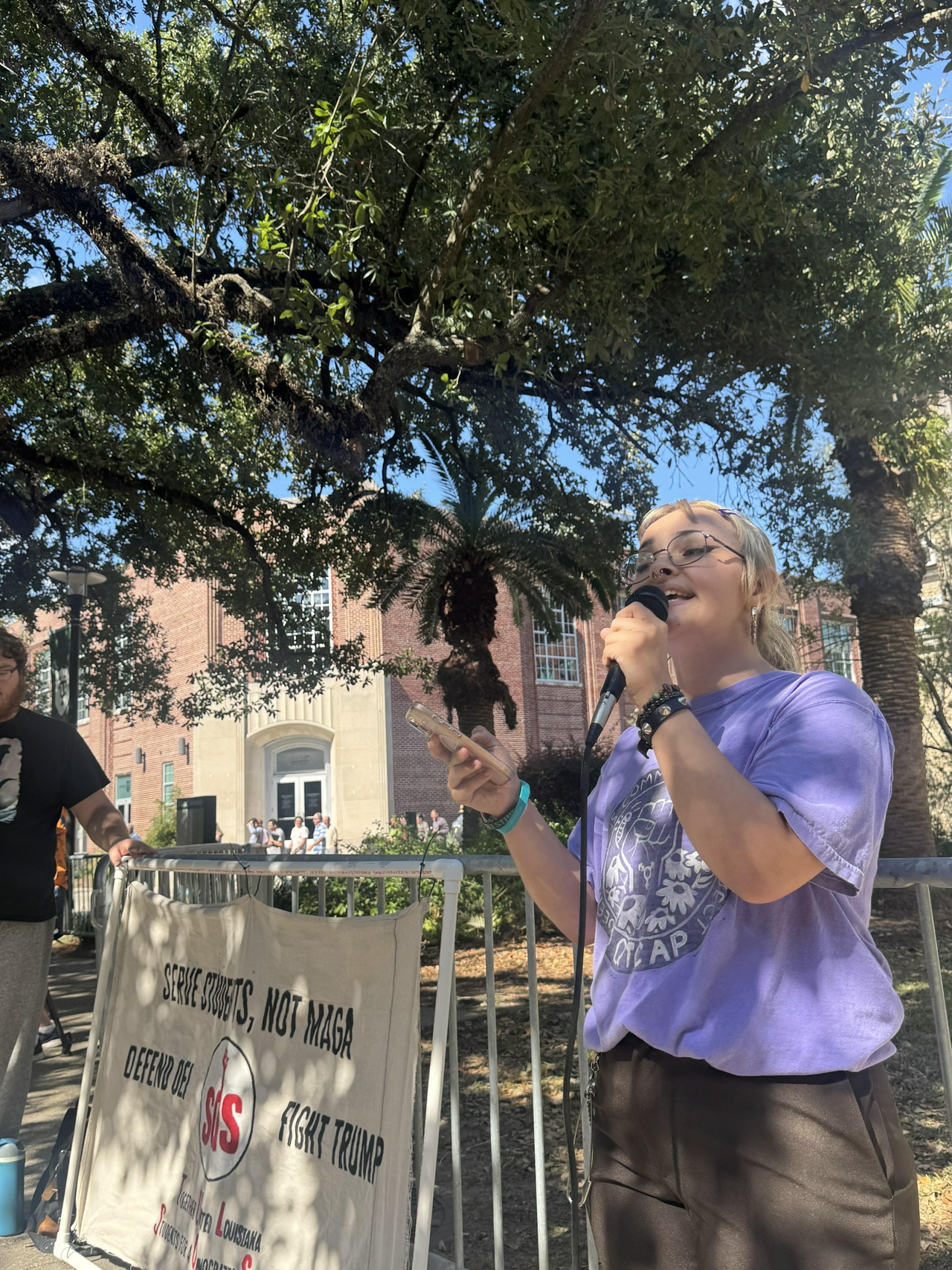 Blu DiMarco, member of the Queer and Trans Community Action Project, speaks to the press in front of Tulane University.