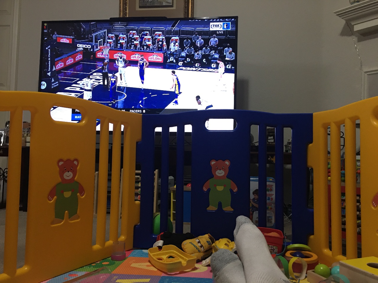 Watching a basketball game from inside the play pen.