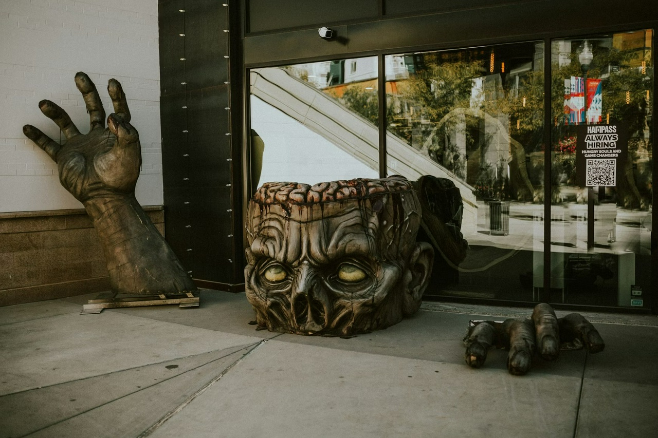 three separate statues - right arm, head, left fingers - giving the illusion of a zombie climbing out of the pavement