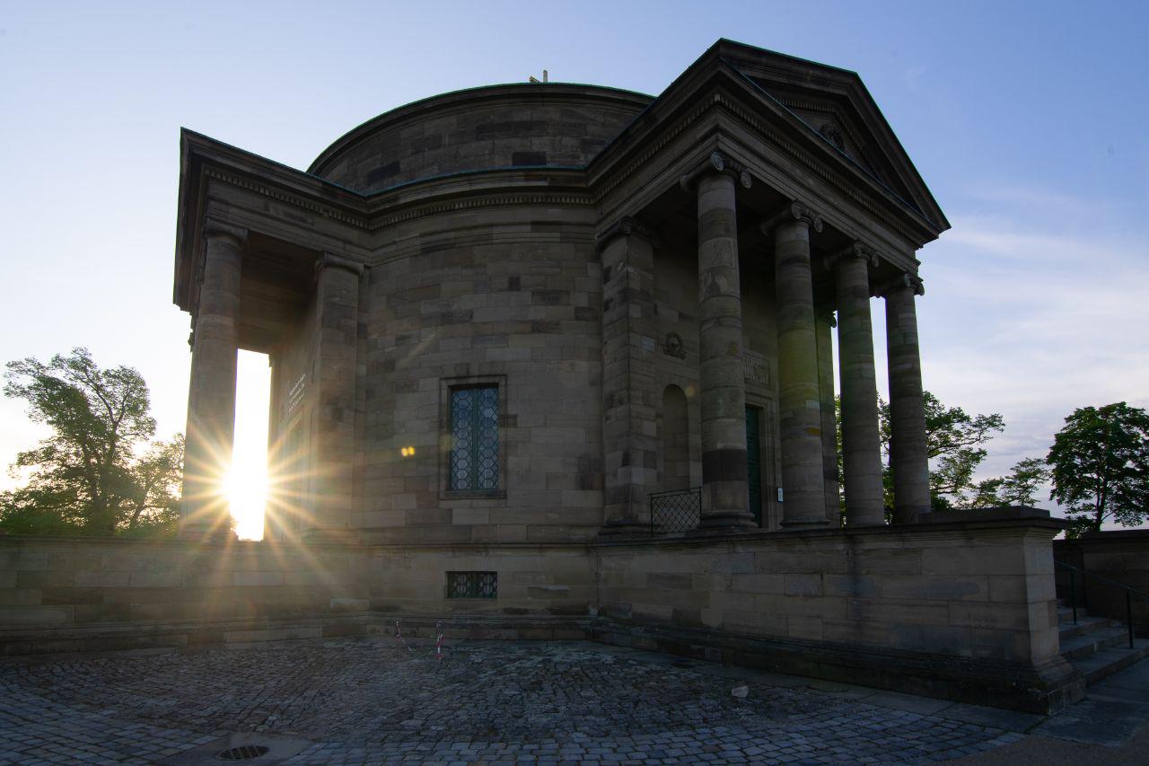 a picture demoing the flare of the lens, the sun rises behind building on left and the light produces a flare on right side of the picture with some noticeable discoloring.