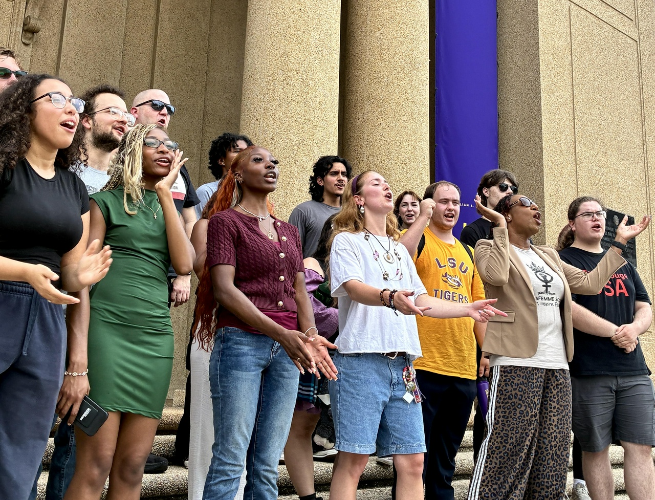 LSU students chant while holding a press conference.
