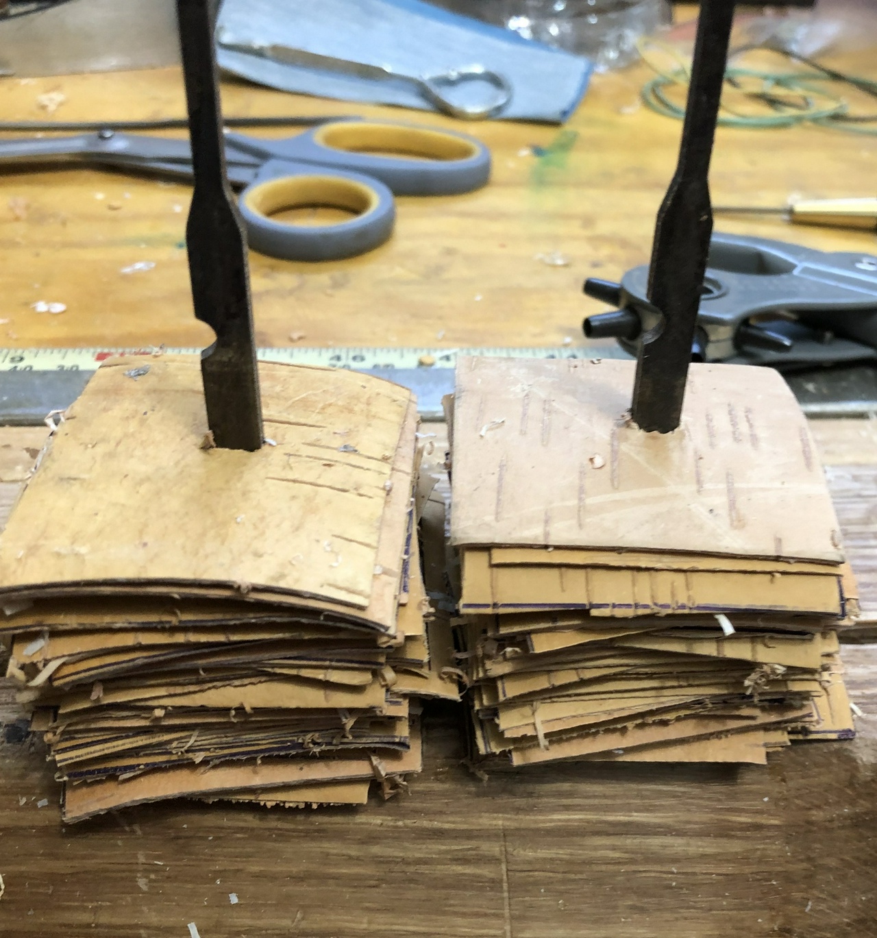 Two knives with partially completed stacks of birch bark