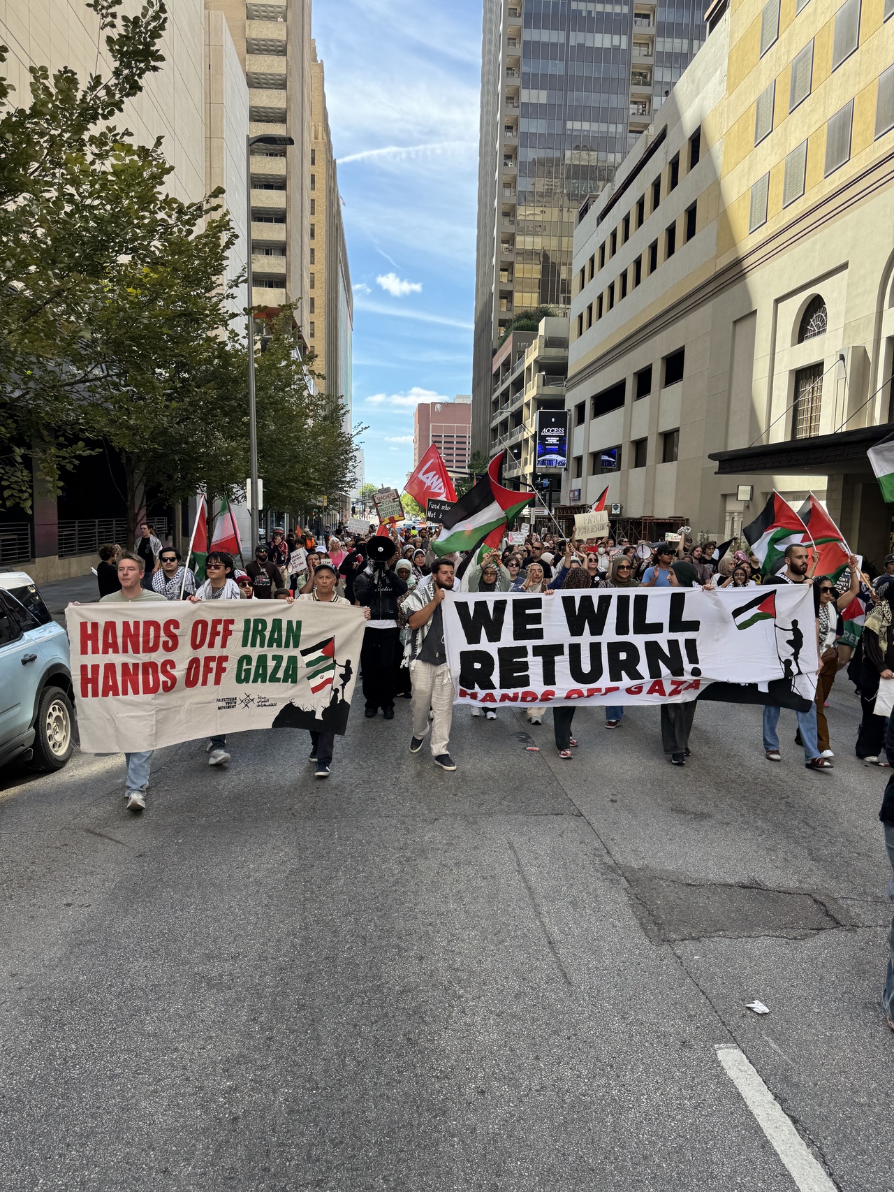 Dallas march in solidarity with Palestine. | Fight Back! News A group of protesters marching on a street holding signs and banners.