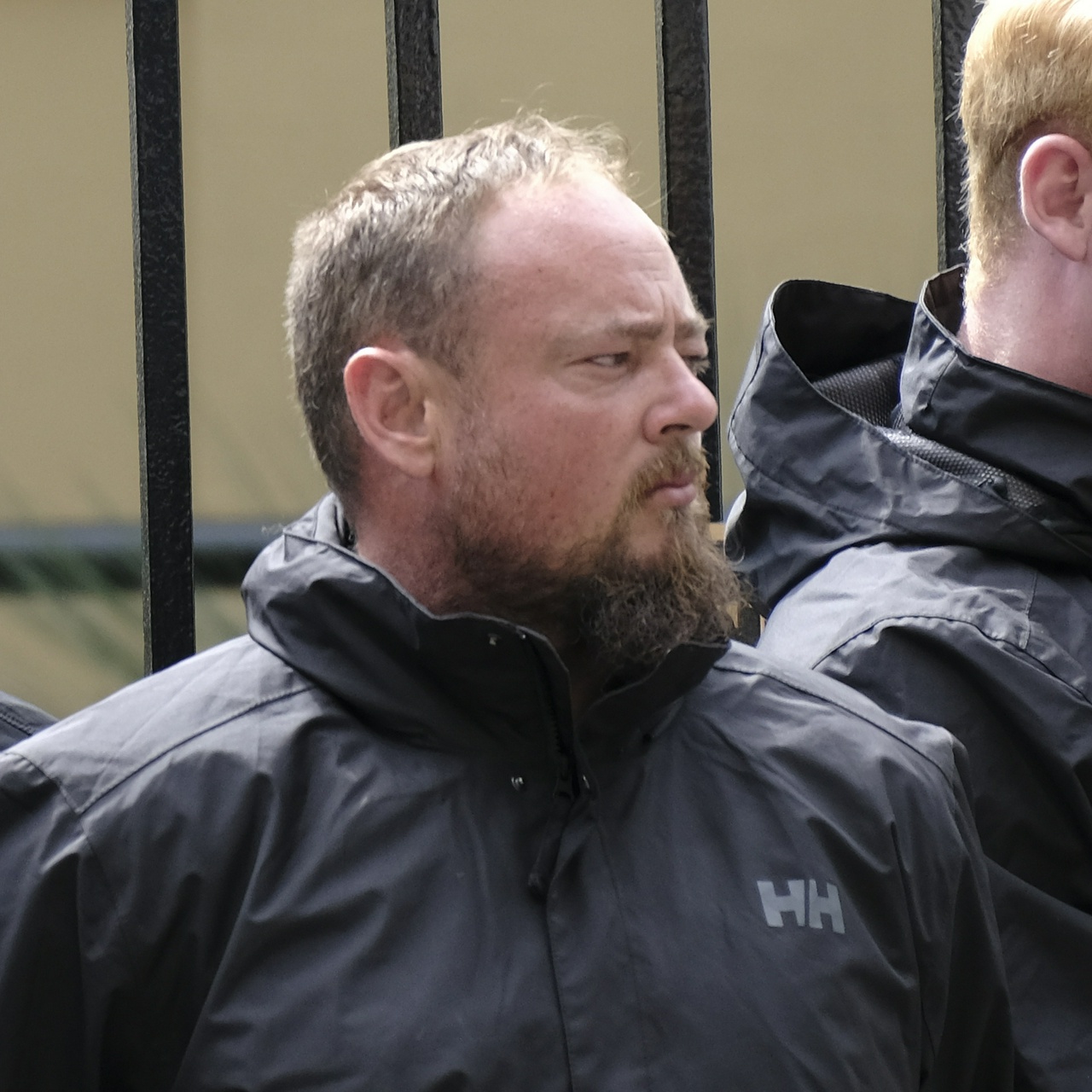 An old guy with a scraggly greying beard and very round face squints grumpily off to one side