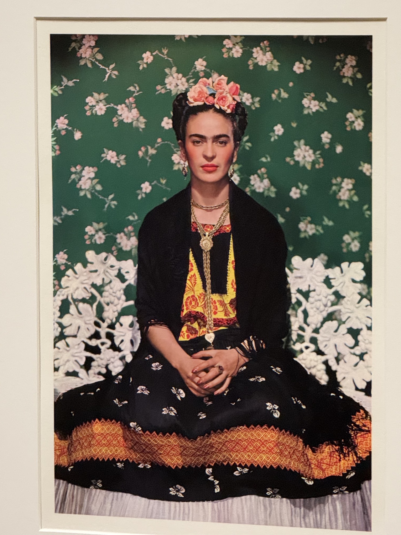 Khalo in front of her famous green floral backdrop