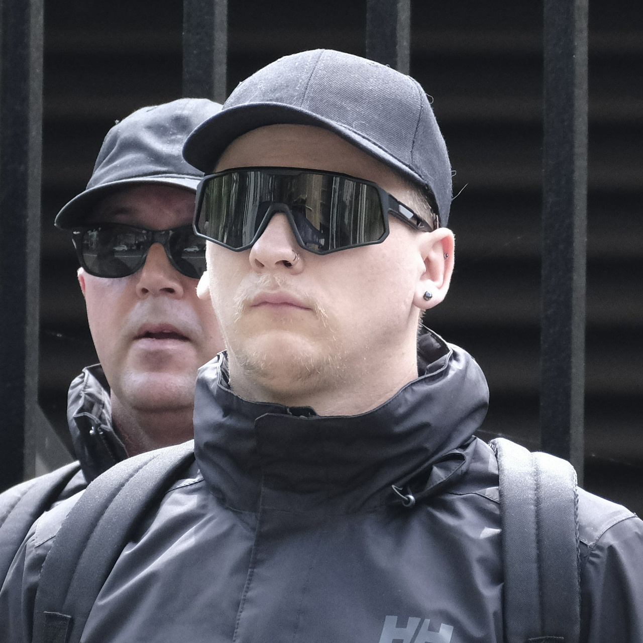 White man with light hair and moustache, with two nose rings and two ear studs