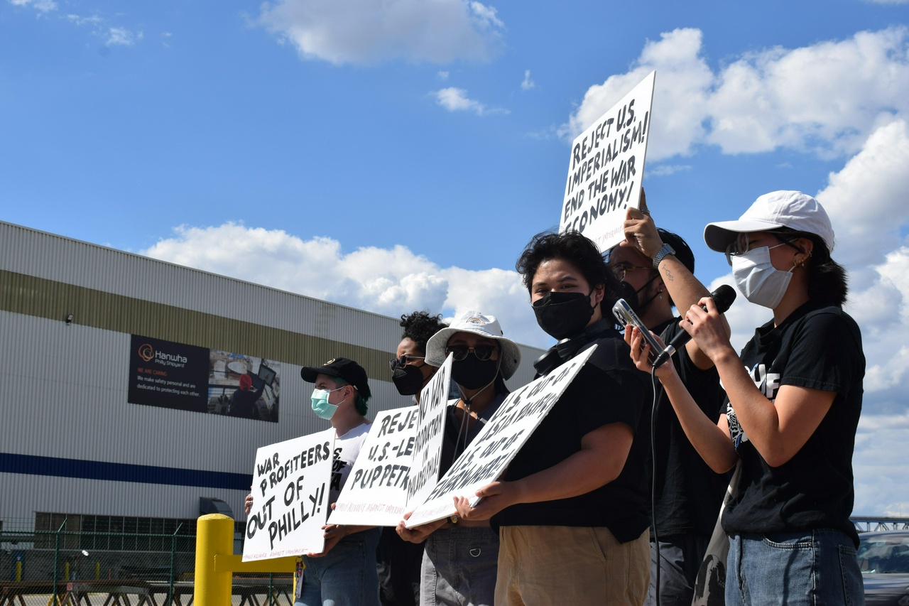 Activists line the entrance to the Hanwha Philly Shipyard.