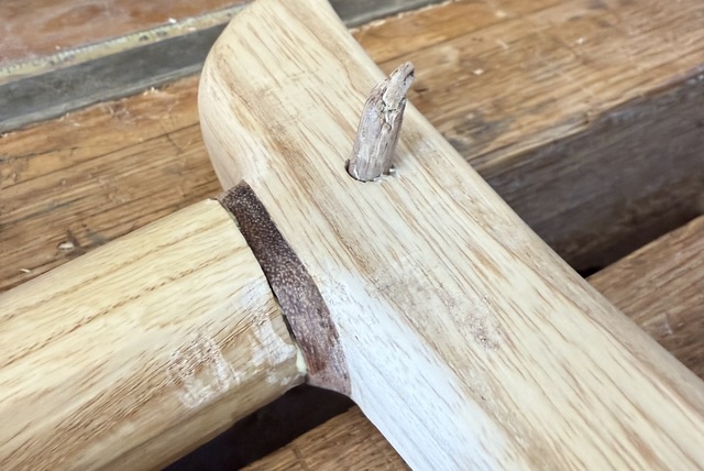 The pointy end of the peg, visibly bent to one side after its trip through the slightly offset holes - the angle is about 30 degrees