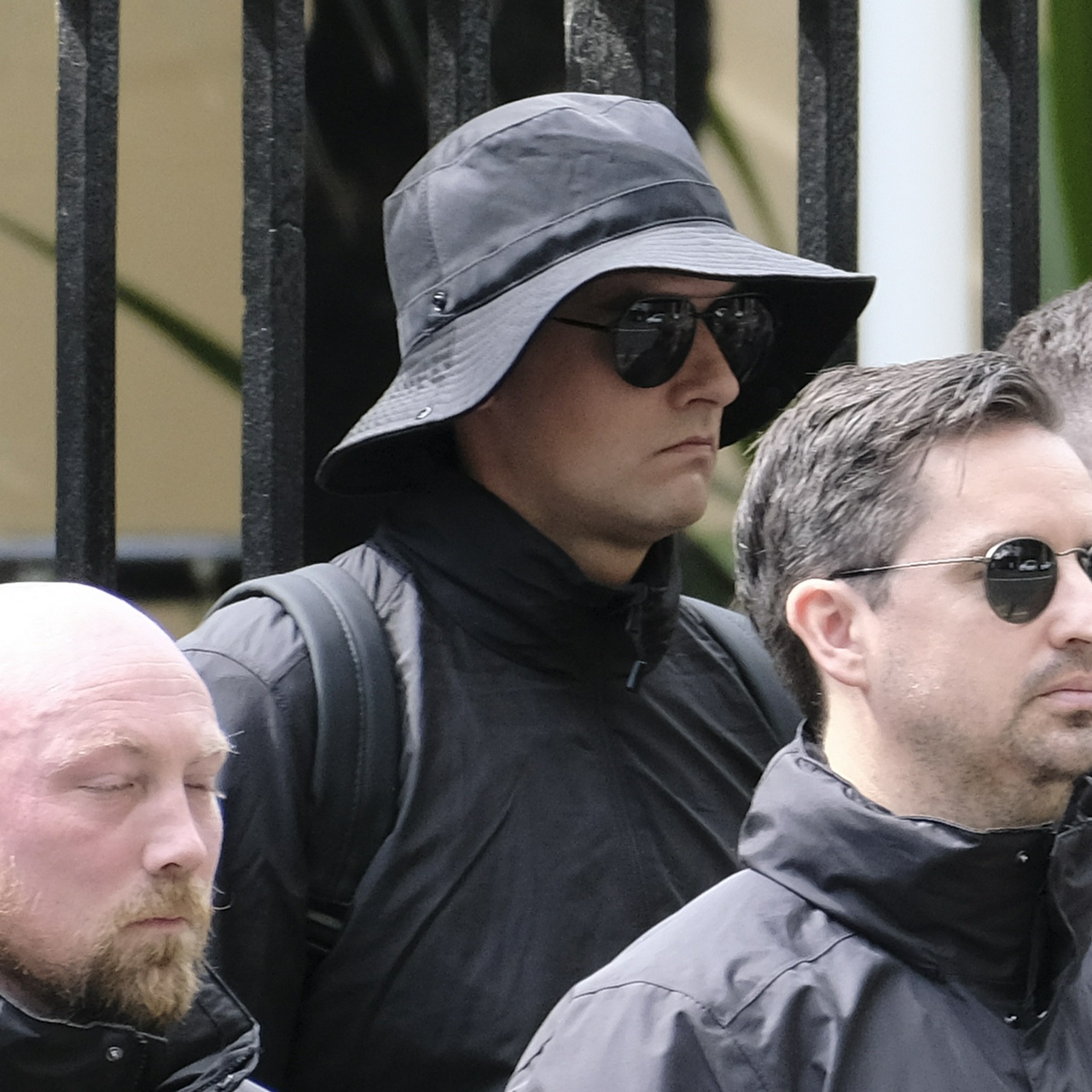 The same man from one side, drawing his chin back into his neck