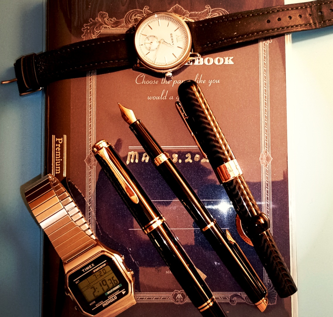 A retro-styled wristwatch, a Timex T-80 Digital watch, Pelikan, Waterman and Conklin Fountain Pens.