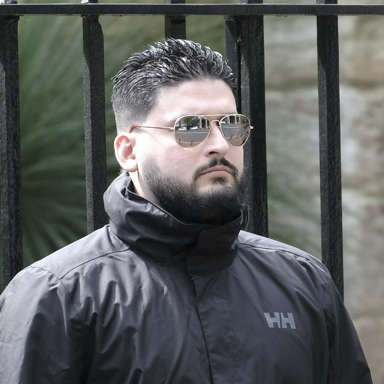 A pudgy ethnic guy with gelled spiked hair and aviators to accompany his jet black beard and small round ears