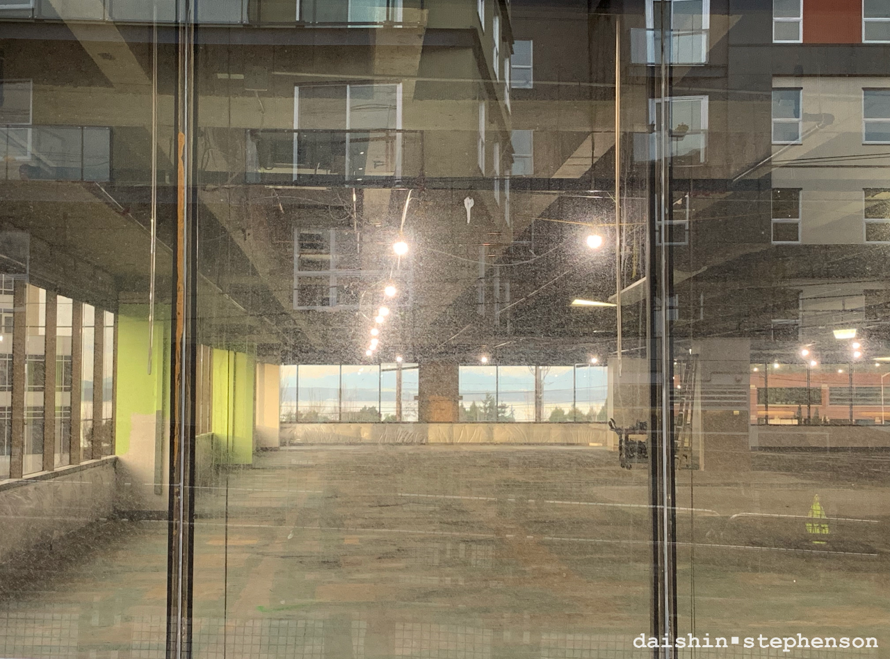 a view through two sets of windows and the reflection of the building behind me