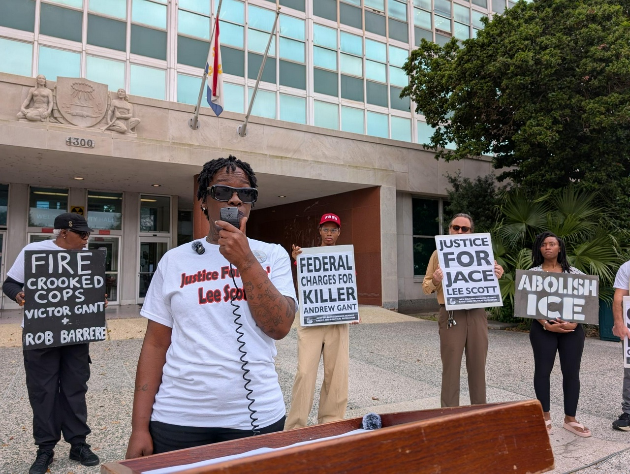Shanta Scott speaks outside city hall among family and supporters.