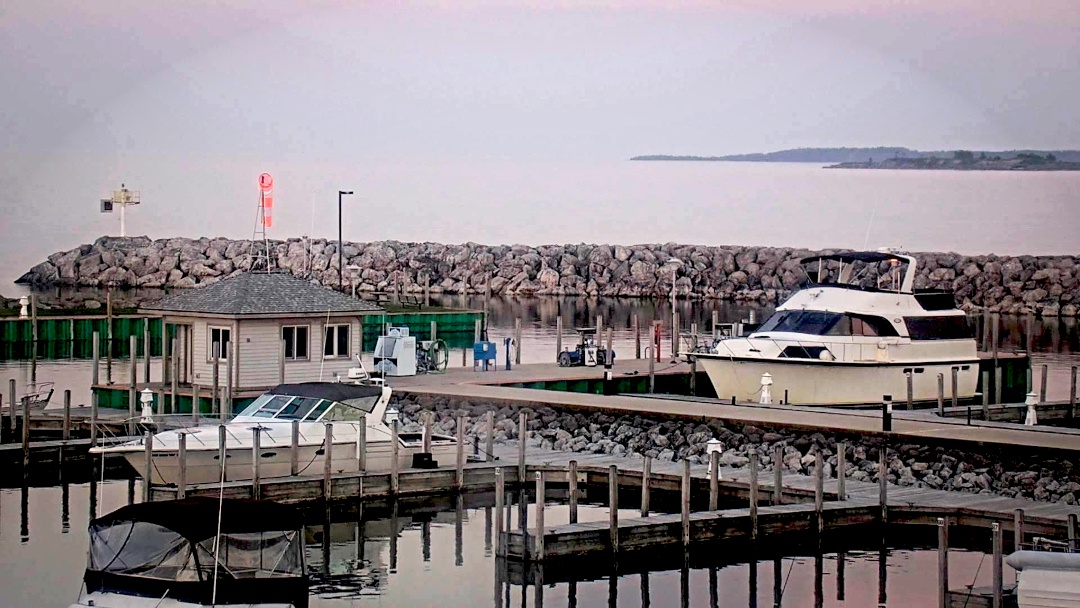 Two boats docked behind a berm.