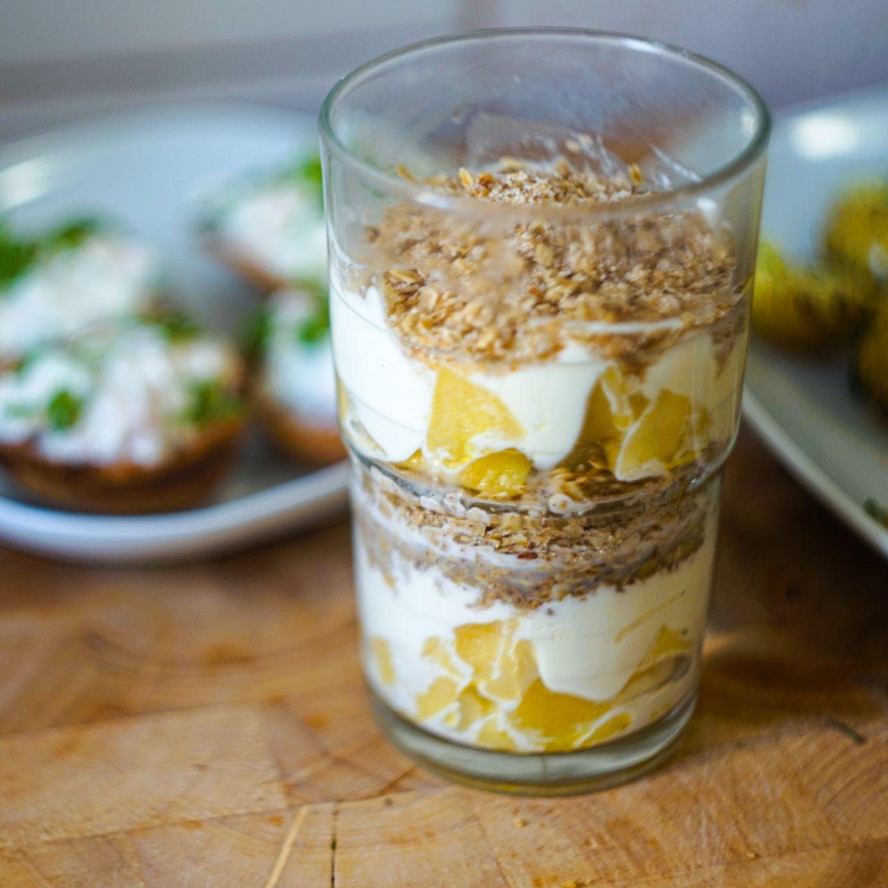 a glas filled with cream, fried apples and bread