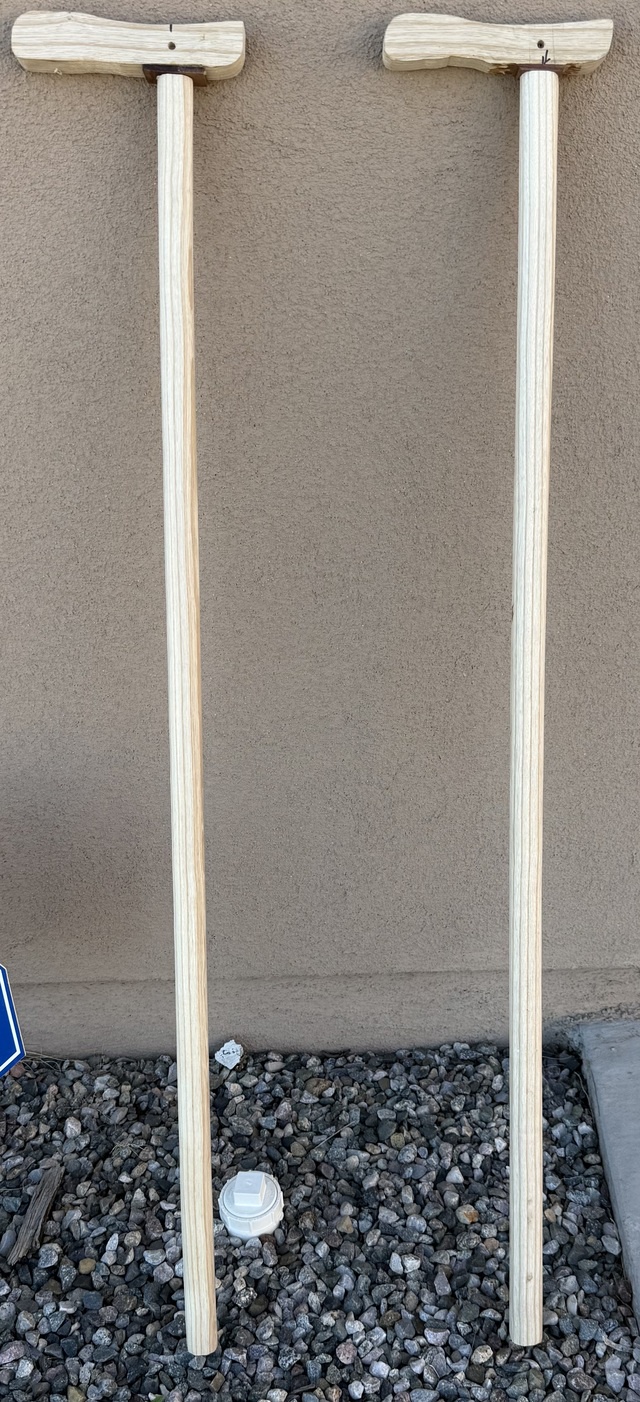 Two canes with round-ish shafts, leaning against the shop wall