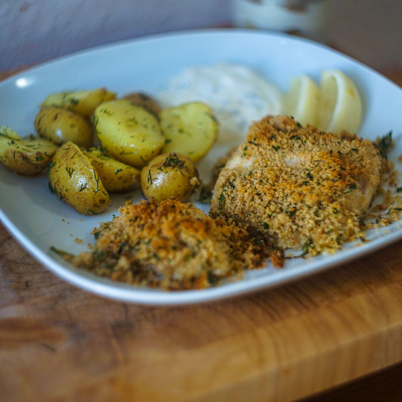 fish and potatoes with source cream and citrus in the background