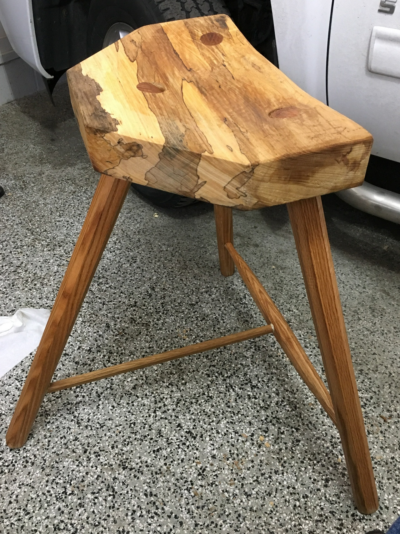 Shop stool, seen in front of a truck on a black, gray, and white epoxy garage floor